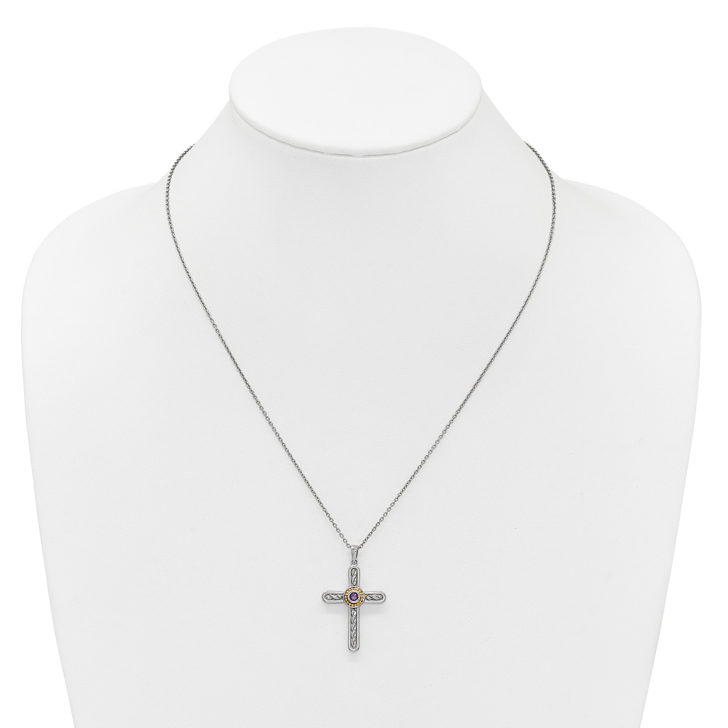 Silver cross pendant necklace with intricate patterns and a central amethyst gemstone on white display