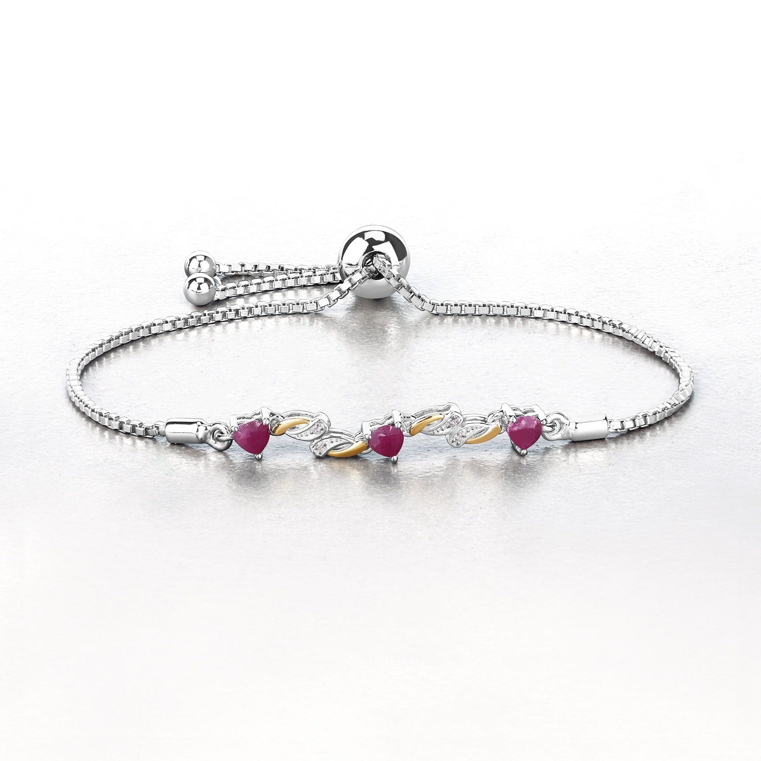 Silver adjustable bracelet with heart-shaped pink gemstones and gold accents on a light background